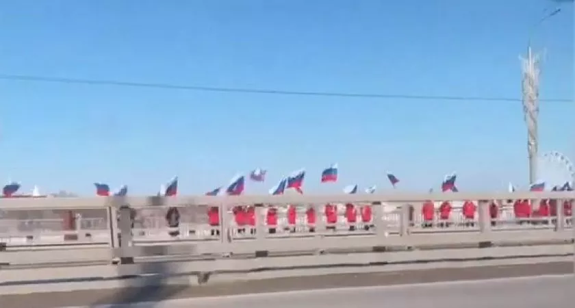 Фото к статье: Вдоль Московского моста выстроились люди с флагами